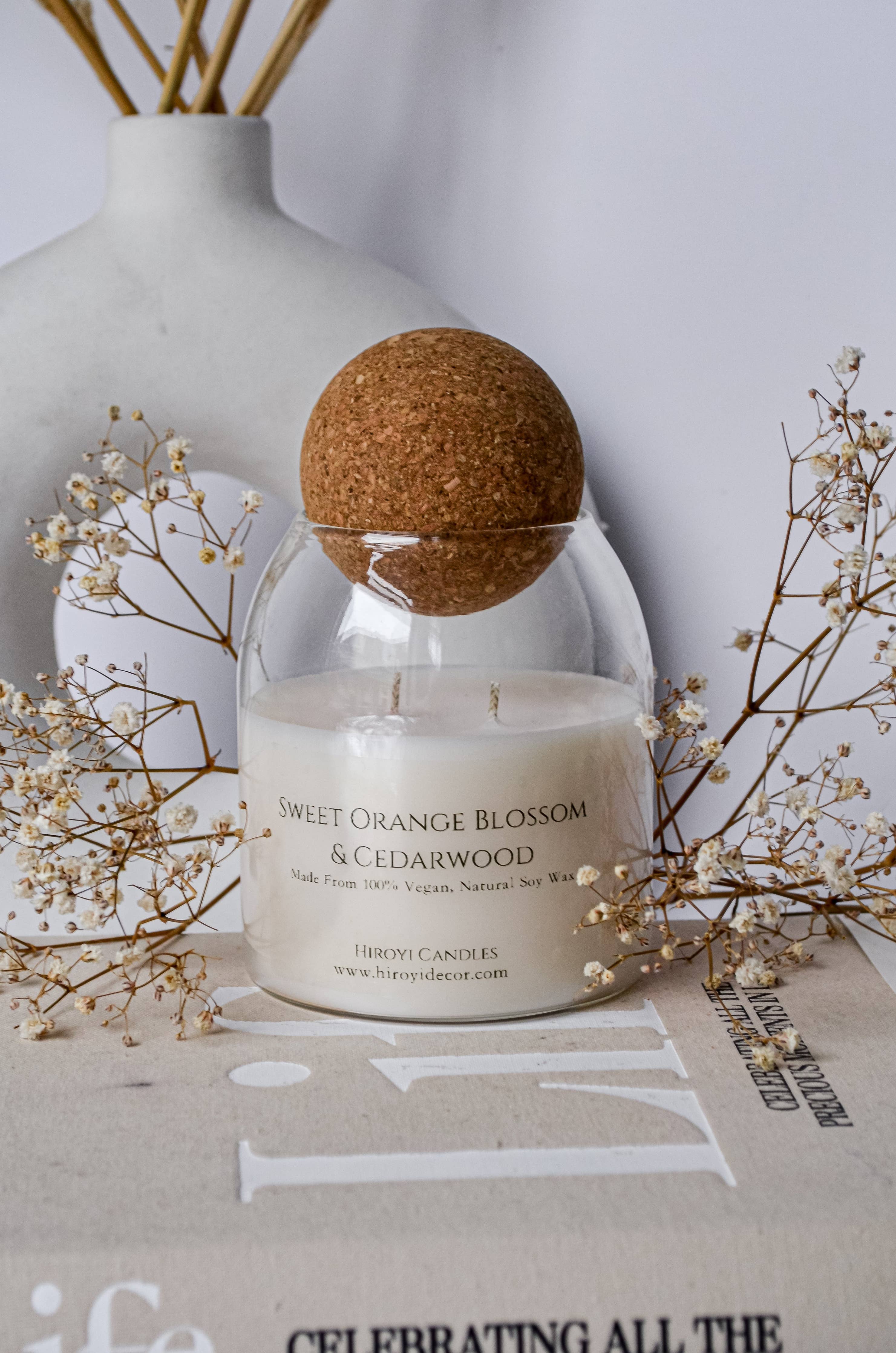 Designer scented candle in a glass jar with a ball‑shaped lid