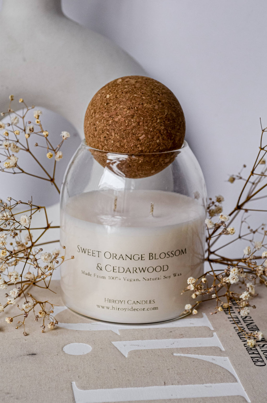 Designer scented candle in a glass jar with a ball‑shaped lid